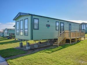 a green tiny house sitting on top of a field at The Endeavour - Uk37771 in Stoupe Brow