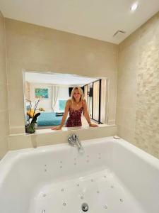 a woman is standing in a bath tub in a bathroom at Les étangs du moulin d'Harcy in Lonny