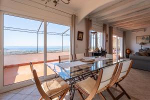 a dining room with a glass table and chairs at Casa con vistas a la Bahia de Roses in Selva de Mar