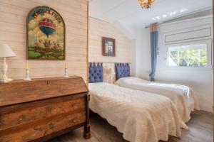 a bedroom with two beds and a dresser in it at Casa con vistas a la Bahia de Roses in Selva de Mar