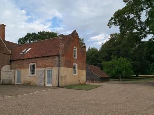 um velho edifício de tijolos com uma porta branca em The Stable em Womenswold