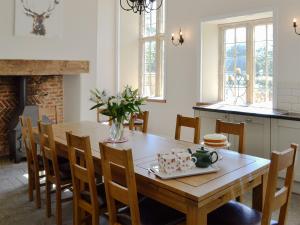 uma cozinha e sala de jantar com uma mesa de madeira e cadeiras em The Farmhouse em Holwell