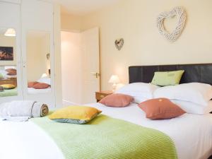 um quarto com duas camas com almofadas em The Byre em Pencombe
