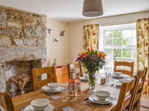 a dining room with a table and a fireplace at Lower Colvannick in Cardinham