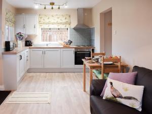 a living room with a couch and a kitchen at Pheasant Lodge in Staithes