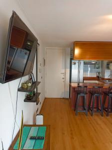 a living room with a kitchen with a counter and chairs at Bellavista Dardignac 28 in Santiago