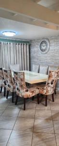 a dining room with a table and chairs and a clock at The Holiday House in Hartbeespoort