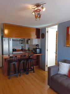 a kitchen with a bar with stools and a couch at Bellavista Dardignac 28 in Santiago +7 photos