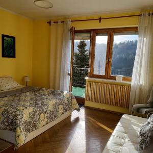 a bedroom with a bed and a large window at Na Markówce in Brenna