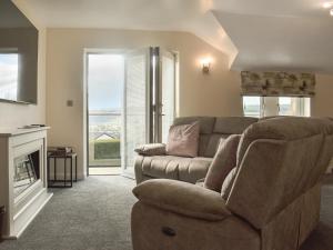 a living room with a couch and a chair at Kinneret Apartment in Silsden