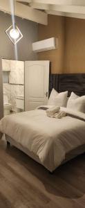 a bedroom with a large bed with white sheets and pillows at The Holiday House in Hartbeespoort