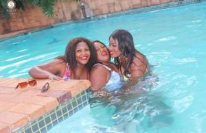 three women are in a swimming pool at The Holiday House in Hartbeespoort