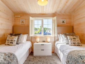 two beds in a room with a window at Chestnut Lodge in Willington