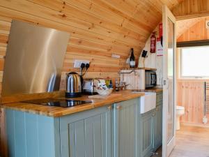 a kitchen with wooden walls and a counter top at Lowside Farm Glamping in Troutbeck