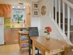 a kitchen with a wooden table and a dining room at Cosy Nook in Ambleside