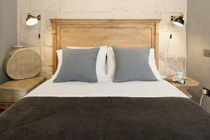 1 dormitorio con 1 cama grande y 2 almohadas en Dar Isla, in the heart of the Three Cities, Malta, en Senglea