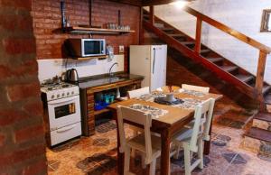 a kitchen with a table and a stove and a refrigerator at Confratelli Cabañas in Paso de la Patria