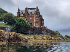 an old castle on an island in the water at Kilbowie Retreat in Oban
