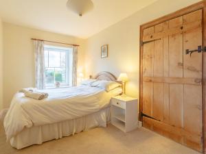 a bedroom with a bed and a large wooden door at Pen Y Crug in Beulah