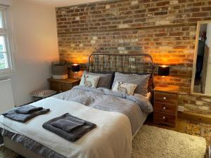 a bedroom with a bed and a brick wall at Jacks House in Hastings