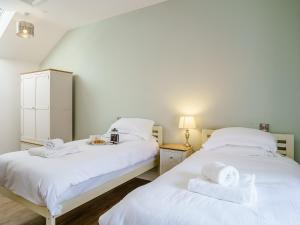 two beds in a room with white towels on them at Ty Felin - Uk12744 in Acrefair
