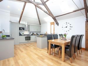 a kitchen and dining room with a wooden table and chairs at The Cow Shed in Tiverton