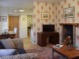 a living room with a television and a fireplace at Gable End Cottage in Goathland