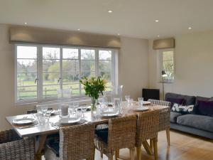 a dining room with a table and some chairs at Brookside Cottage in Burley