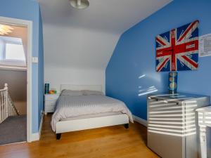 um quarto com uma cama e uma parede azul em Relax In Ramsgate em Ramsgate