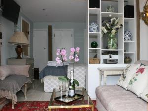 a living room with a couch and a table with flowers at The Cart Shed in Ibstone