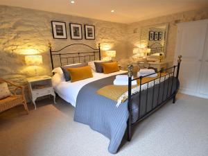 a bedroom with a large bed with yellow pillows at The Long Barn in Crowan