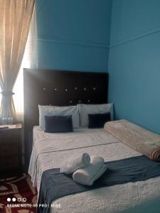 a blue bedroom with a bed with towels on it at The Croc Guest house in Springs