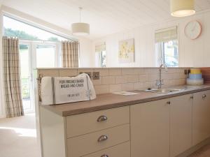 a kitchen with white cabinets and a box on the counter at Lodge 5 in Kinlet