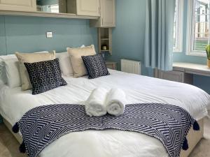 a bedroom with a bed with towels on it at Sunnyside Lodge in Monreith