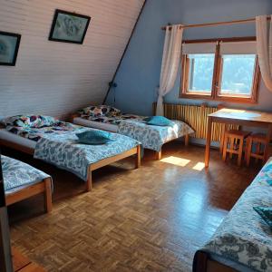 a room with three beds and a table at Na Markówce in Brenna