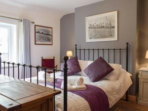 sypialnia z łóżkiem z fioletowymi poduszkami w obiekcie Lamb Inn w mieście Stoke Prior