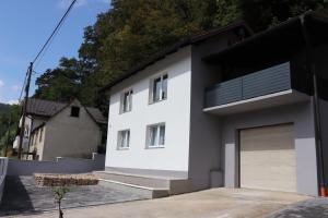 une maison blanche avec un garage dans l'établissement ŠafraM, à Ðurmanec