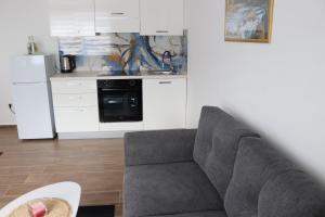 a living room with a couch and a kitchen at Apartman ŠafraM in Ðurmanec