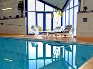 two chairs sitting next to a swimming pool at Goose Cottage- Uk6737 in Lydstep
