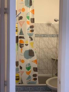 y baño con cortina de ducha y lavamanos. en Charming Private Rooms in a Great Location, en Budapest