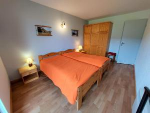 una camera da letto con un grande letto con copriletto arancione di Appartement Autrans-Méaudre en Vercors-Autrans, 2 pièces, 5 personnes - FR-1-737-34 ad Autrans
