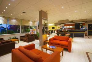 a living room with orange furniture and a lobby at Kyparissia Beach Hotel in Kyparissia