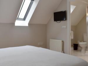 um quarto com uma cama branca e uma clarabóia em Hollies Cottage 16 - Uck4539 em Martock