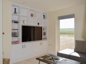 a living room with a flat screen tv on a wall at Puxton Lodge in Fordwich