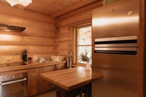 uma cozinha com um frigorífico e uma parede de madeira em Viesu nams “Kalna Raskumi” em Vecpiebalga