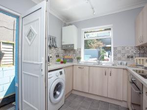 a kitchen with a washer and dryer in it at Harbour Retreat in Paignton