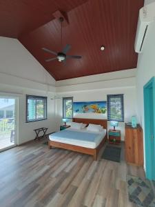 um quarto com uma cama e uma ventoinha de tecto em Blue Lizard House em San Andrés