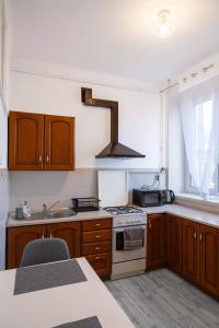 La cuisine est équipée de placards en bois et d'un four avec plaques de cuisson. dans l'établissement ClickTheFlat Wilcza 35 City Center Apart Rooms, à Varsovie