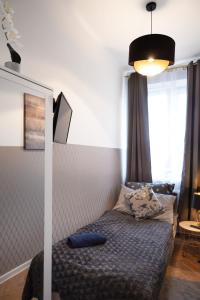 a small bedroom with a bed and a lamp at ClickTheFlat Wilcza 35 City Center Apart Rooms in Warsaw