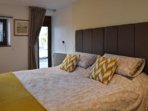 a bedroom with a large bed with two pillows on it at 1 Barnagh Barn in Kirkmichael